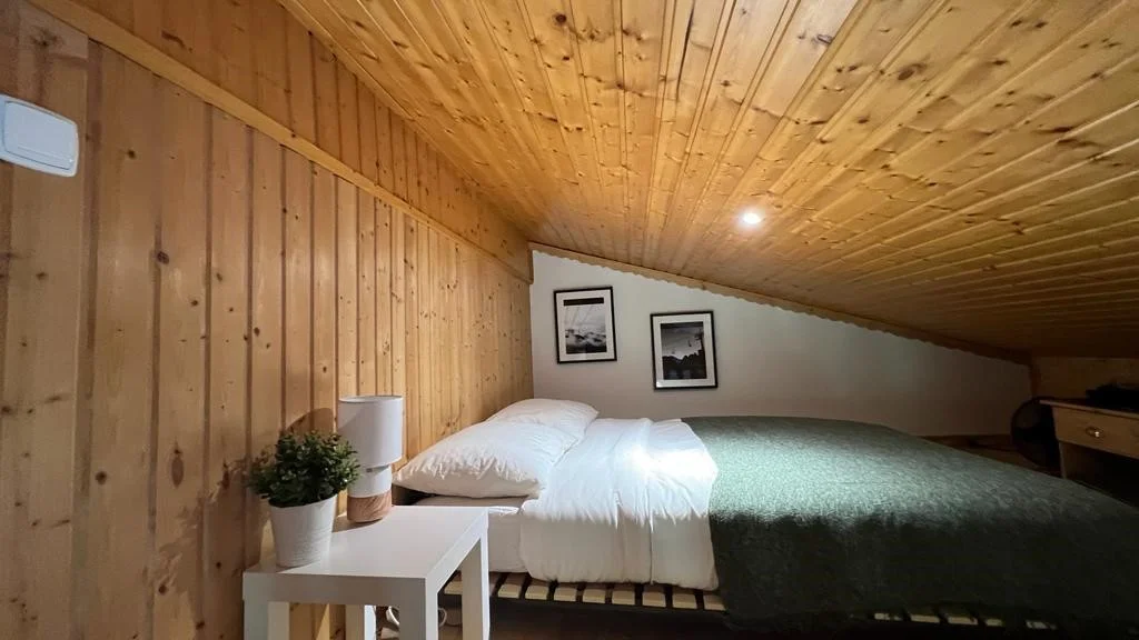 Double bed on the mezzanine under the wood panelling